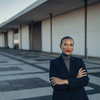 2024 AIA President Kimberly Dowdell stands arms-crossed outside a building