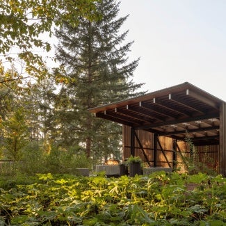 The architecture is deliberately deferential to the landscape, providing a quiet backdrop and flexible gathering space.