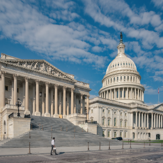 Wide angle view US Capitol with large blue sky and clouds