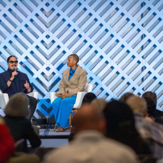 Architects Preeti Sriratana and Kimberly Dowdell sit on a stage sharing a conversation. 