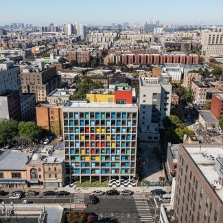 Gridded concrete façade with colorful painted steel panels stands out in
