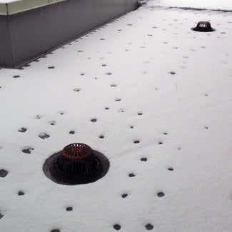 Roof fasteners on snowy roof show thermal bridging