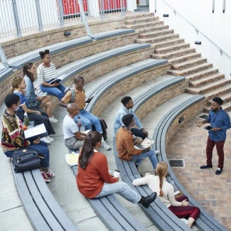 Male teacher lecturing at an outdoor classroom amphitheater 