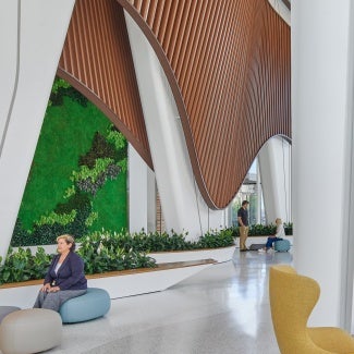 The indoor public spaces begin with a glazed winter garden that provides a hotel-like entry experience. The use of natural planting as well as warm and comforting building material such as wood soffits and textured brick reduce visitors' and patients' anxiety and provide a welcoming, clear, and convenient entry for the community.