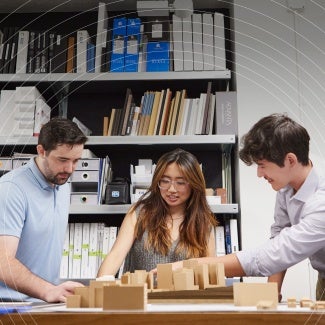 Member architects reviewing architectural model.