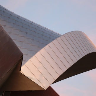 Bronze building in front of pink sky