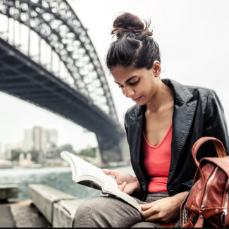 Woman reading under a bridge