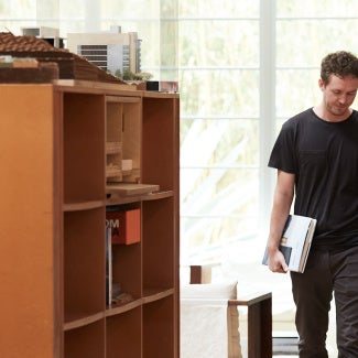 Two architects walking in a library beside a bookshelf