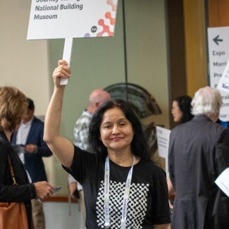 Woman holding up a sign at AIA conference