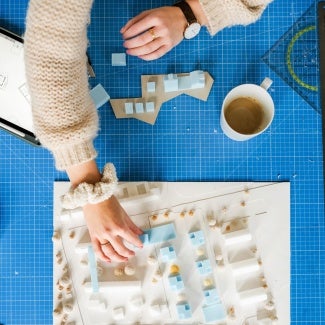 Hands working on an architectural model