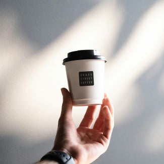 Barista holding a Grace Street to-go coffee cup