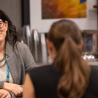 Two females speaking with one another in a business setting