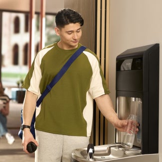 A person using a water fountain in a school