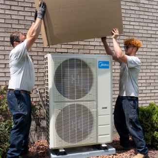 Two people working on an HVAC system
