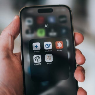 Phone being held up showing AI apps